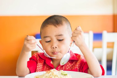 Küçük tatlı çocuk, öğle yemeği için evde spagetti yiyor, lezzetli yemekler yiyor.