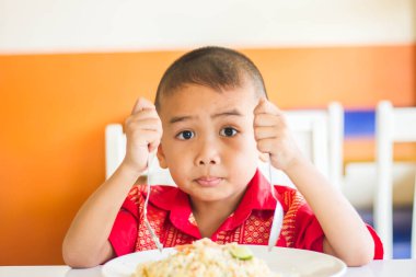 Küçük tatlı çocuk, öğle yemeği için evde spagetti yiyor, lezzetli yemekler yiyor.