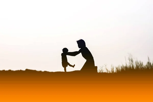 Moeder Aangemoedigd Haar Zoon Buitenshuis Zonsondergang Silhouet Concept — Stockfoto