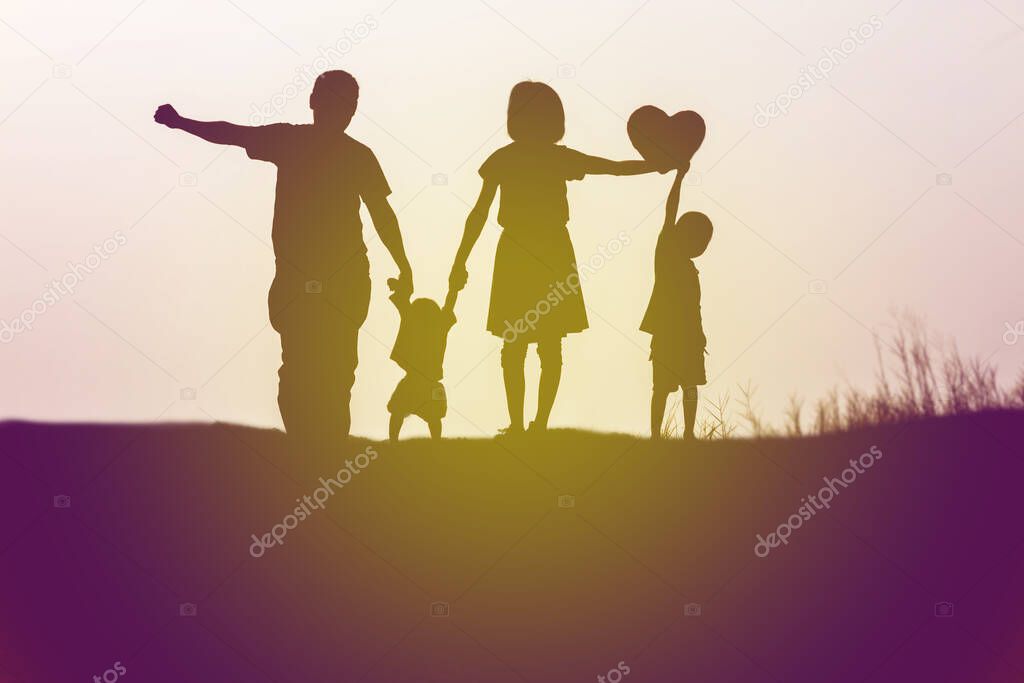 Silhouettes of happy parents having good time with their little 