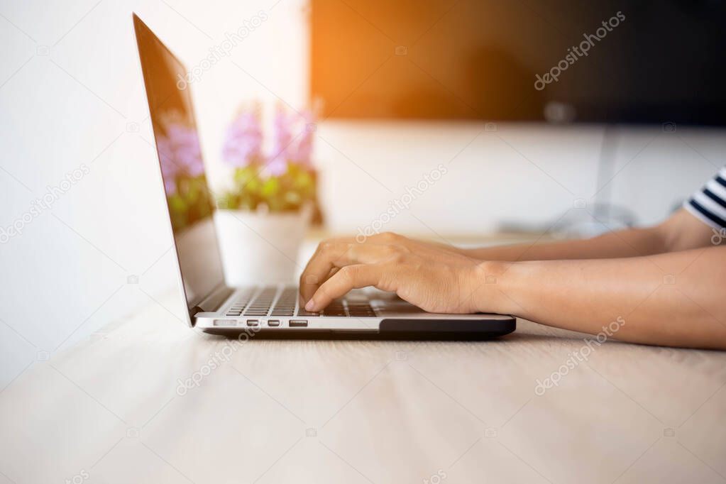 Woman hand using touchpad on laptop at home stock photo