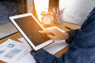 Ofis masasında otururken tablet kullanan güzel kadın..