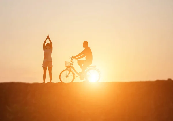 对夫妇驾驶自行车快乐时间日落的剪影 — 图库照片