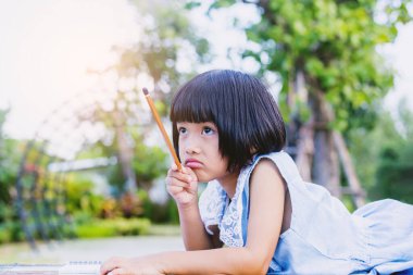 Bulanık yeşil arka planda mutlu tatlı kız çocuğu.