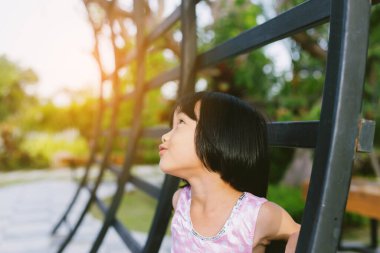 Bulanık yeşil arka planda mutlu tatlı kız çocuğu.