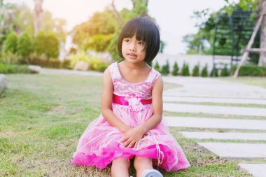 Bulanık yeşil arka planda mutlu tatlı kız çocuğu.