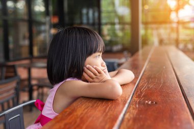 Bulanık yeşil arka planda mutlu tatlı kız çocuğu.