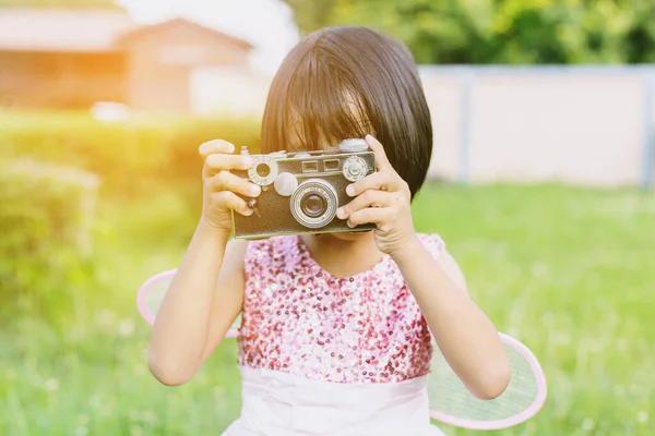 かわいいです幸せな女の子とともにヴィンテージ写真カメラ屋外 — ストック写真