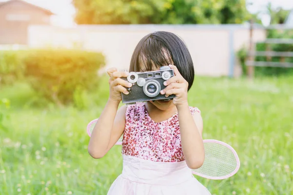 かわいいです幸せな女の子とともにヴィンテージ写真カメラ屋外 — ストック写真