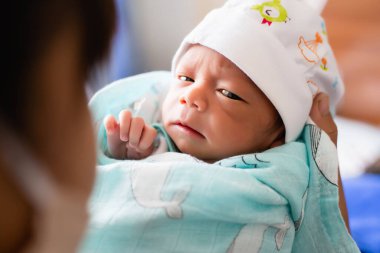 Yeni doğmuş bebek kameraya bakıyor.