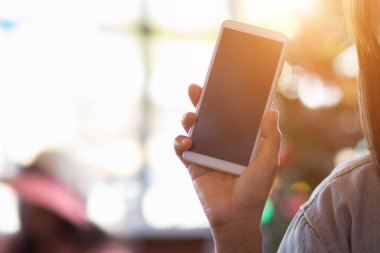 Arka planda cep telefonu tutan kadın