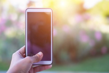 Arka planda cep telefonu tutan kadın