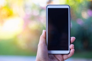 Arka planda cep telefonu tutan kadın