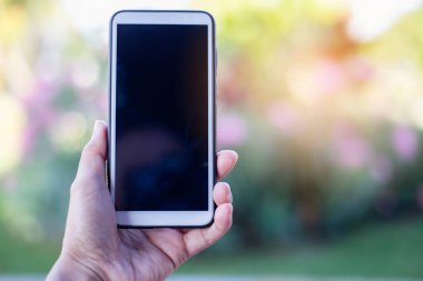 Arka planda cep telefonu tutan kadın