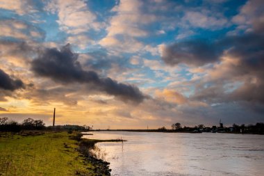 Nehrin üzerindeki güzel gökyüzü ve dramatik bulutlar Ijssel 'i doğaya yakın olan Fortmond ili, Hollanda Overijssel bölgesi.
