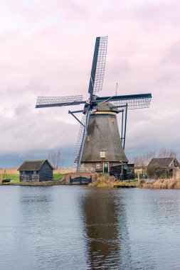 Kışın yel değirmenleri ve şiddetli bulutlu bir gökyüzü, Kinderdijk 'in rıhtımında Alblasserwaard' ın ulusal mirası