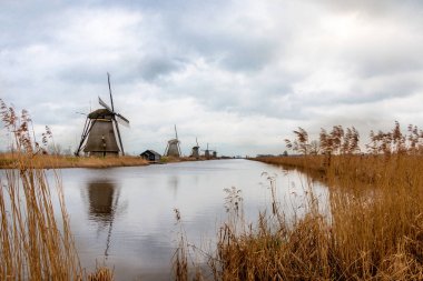 Kışın yel değirmenleri ve şiddetli bulutlu bir gökyüzü, Kinderdijk 'in rıhtımında Alblasserwaard' ın ulusal mirası