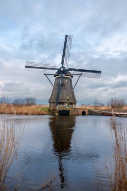 Kışın yel değirmenleri ve şiddetli bulutlu bir gökyüzü, Kinderdijk 'in rıhtımında Alblasserwaard' ın ulusal mirası