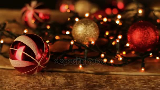 Christmas decoration with balls and lights on wooden table. — Stock Video