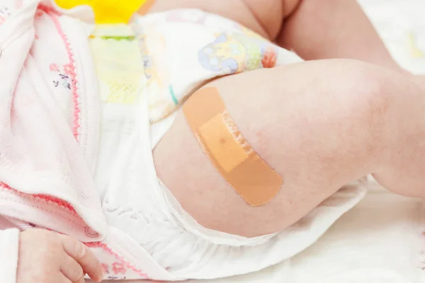 Leg of a newborn with the patch after vaccination. — Stock Photo, Image