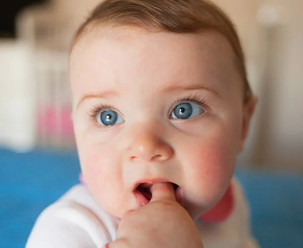 Teething concept. Baby girl with finger in mouth. — Stock Photo, Image