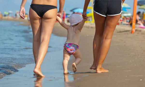 Mamá enseña a su hija a caminar a la playa . — Foto de Stock