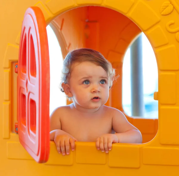 Menina brinca na praia em uma casa em miniatura — Fotografia de Stock