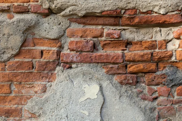 Old brick wall with peeling plaster grunge background — Stock Photo, Image