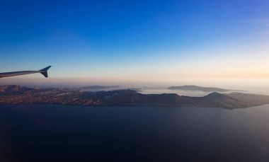 Uçak penceresinden görüldüğü gibi Santorini Adası'nın muhteşem havadan görünümü.