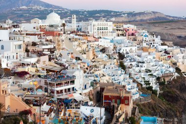 Işıklı lüks balkon güverte ve patios Fira Town alacakaranlıkta restoranları ile.