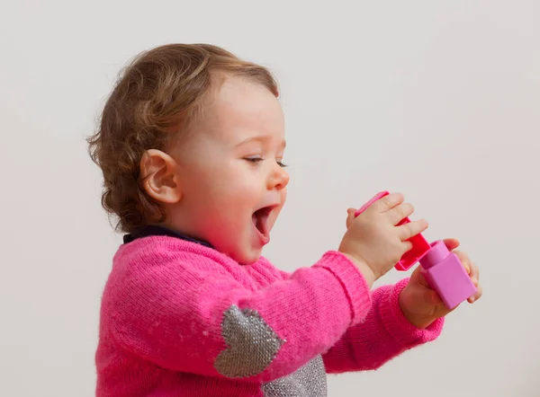 Baby girl plays with soft rubber building blocks — Stock Photo, Image