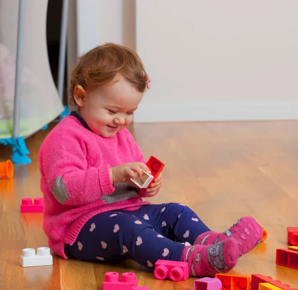 Kleinkind Baby Mädchen spielt mit Gummibausteinen. — Stockfoto