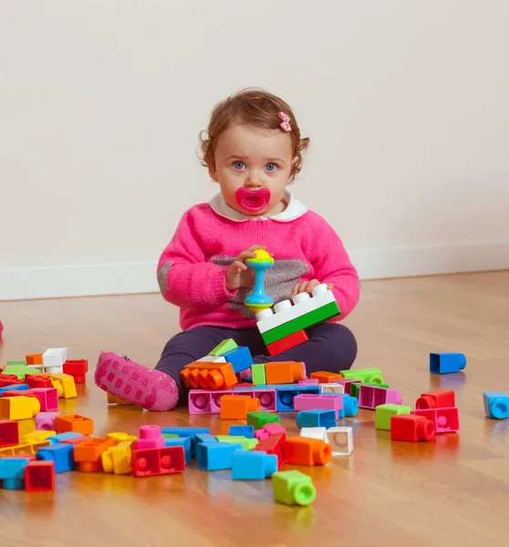 Bébé fille tout-petit jouant avec des blocs de construction en caoutchouc . — Photo