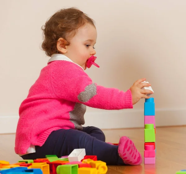 Kleinkind Baby Mädchen spielt mit Gummibausteinen. — Stockfoto