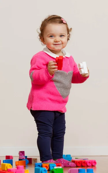 Kleinkind Baby Mädchen spielt mit Gummibausteinen. — Stockfoto