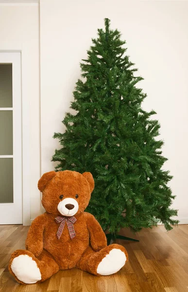 Bare artificial christmas tree with teddy bear — Stock Photo, Image