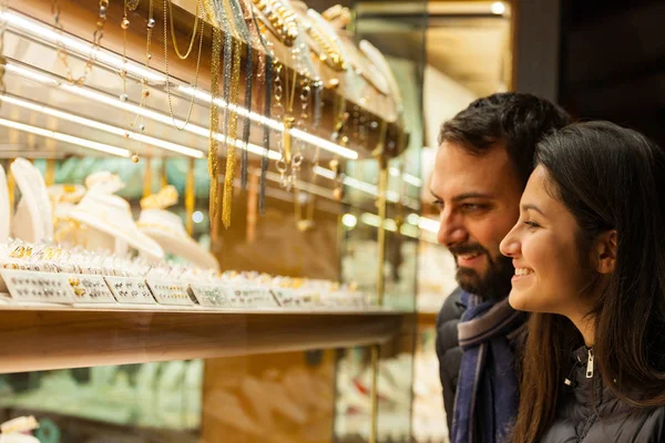 Couple looking at the showcase of an outdoor jewelry. — Stock Photo, Image