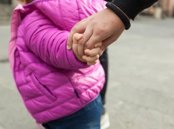 一个蹒跚学步的女孩在冬天的时候和母亲牵手 危险概念 — 图库照片