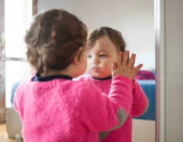 Batole dětská dívka si hraje s zrcadlem v ložnici — Stock fotografie