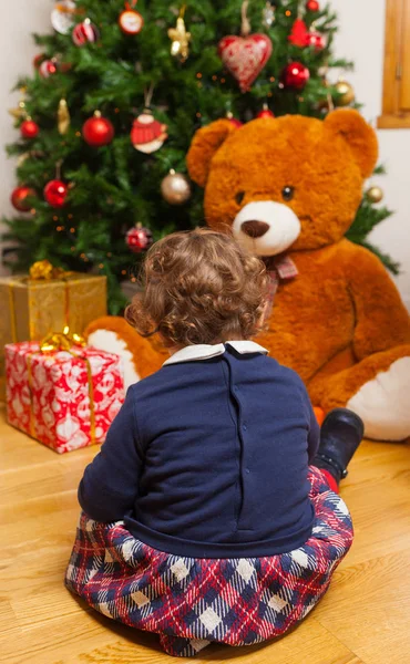 Tddler girl mit Geschenken und Weihnachtsbaum. — Stockfoto