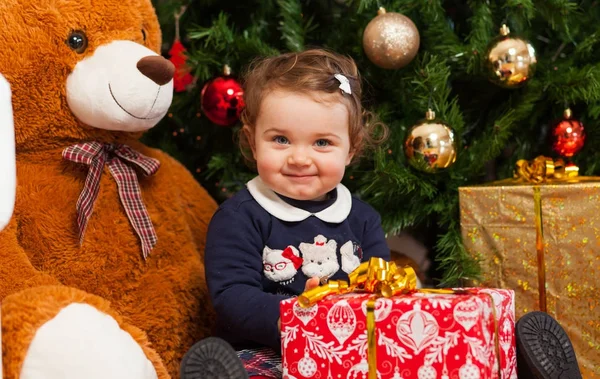 Tddler girl mit Geschenken in der Nähe des Weihnachtsbaums. — Stockfoto