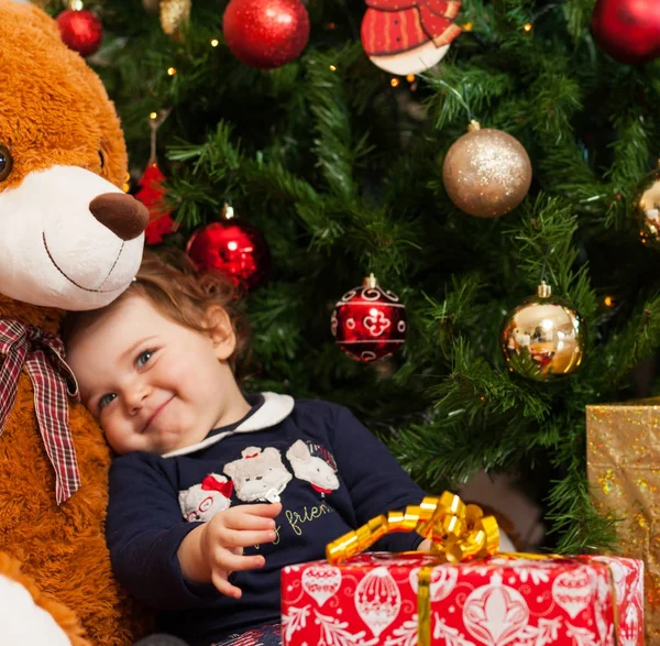 Tddler girl mit Geschenken in der Nähe des Weihnachtsbaums. — Stockfoto