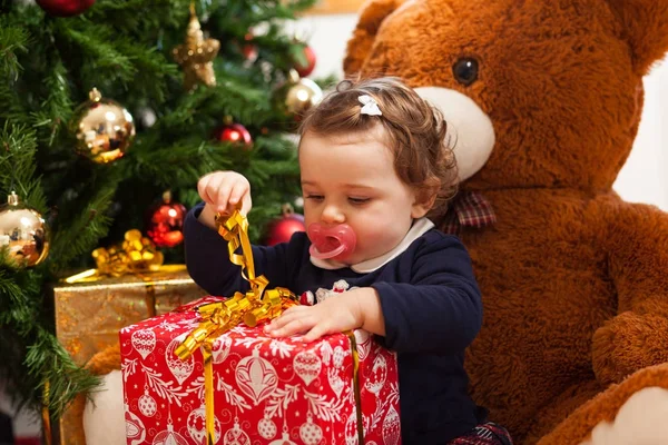 Tddler flicka med gåvor nära julgran. — Stockfoto