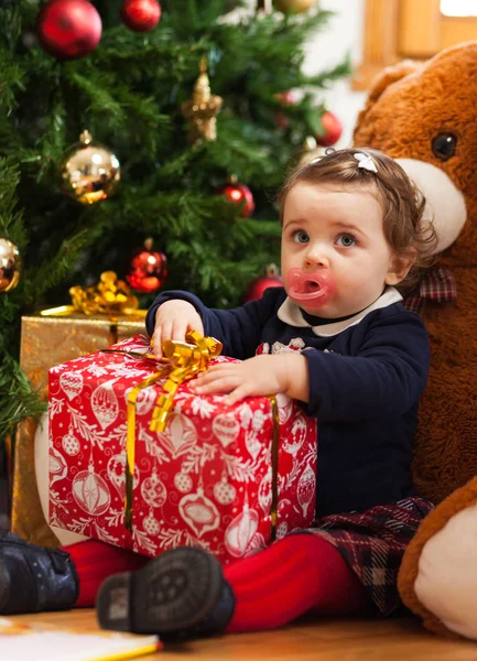 Tddler girl mit Geschenken in der Nähe des Weihnachtsbaums. — Stockfoto