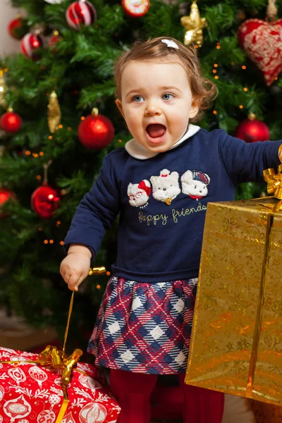 Девочка с подарками возле новогодней елки . — стоковое фото