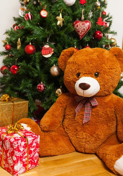 Osito de peluche cerca del árbol de Navidad con regalos — Foto de Stock