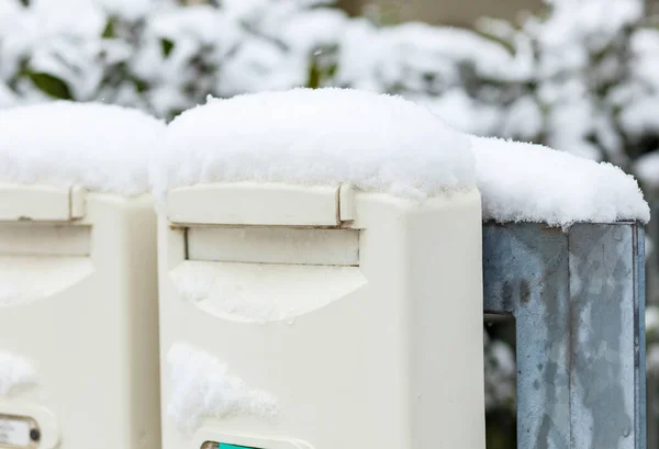 Cassette postali drappeggiate con neve appena caduta — Foto Stock