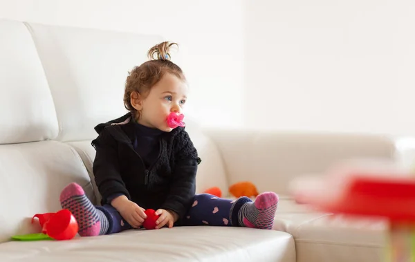 Portrait toddler baby girl playing on the sofa. — Stock Photo, Image