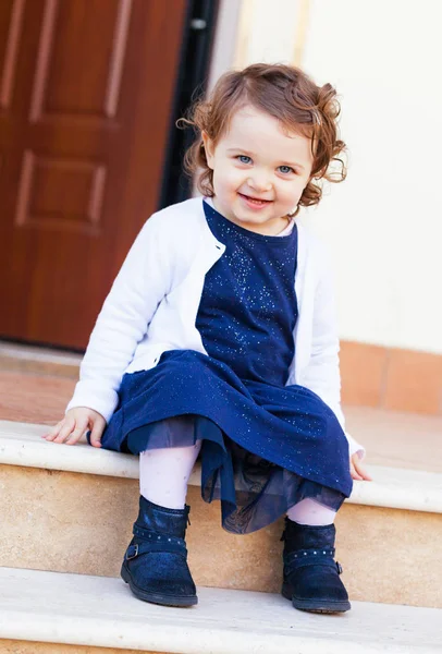 Portréja egy gyönyörű kis lány ült a lépcsőn — Stock Fotó