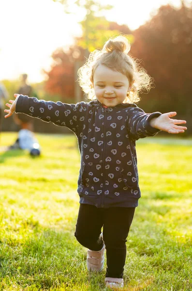 Babymeisje speelt in het park in tegenlicht. — Stockfoto